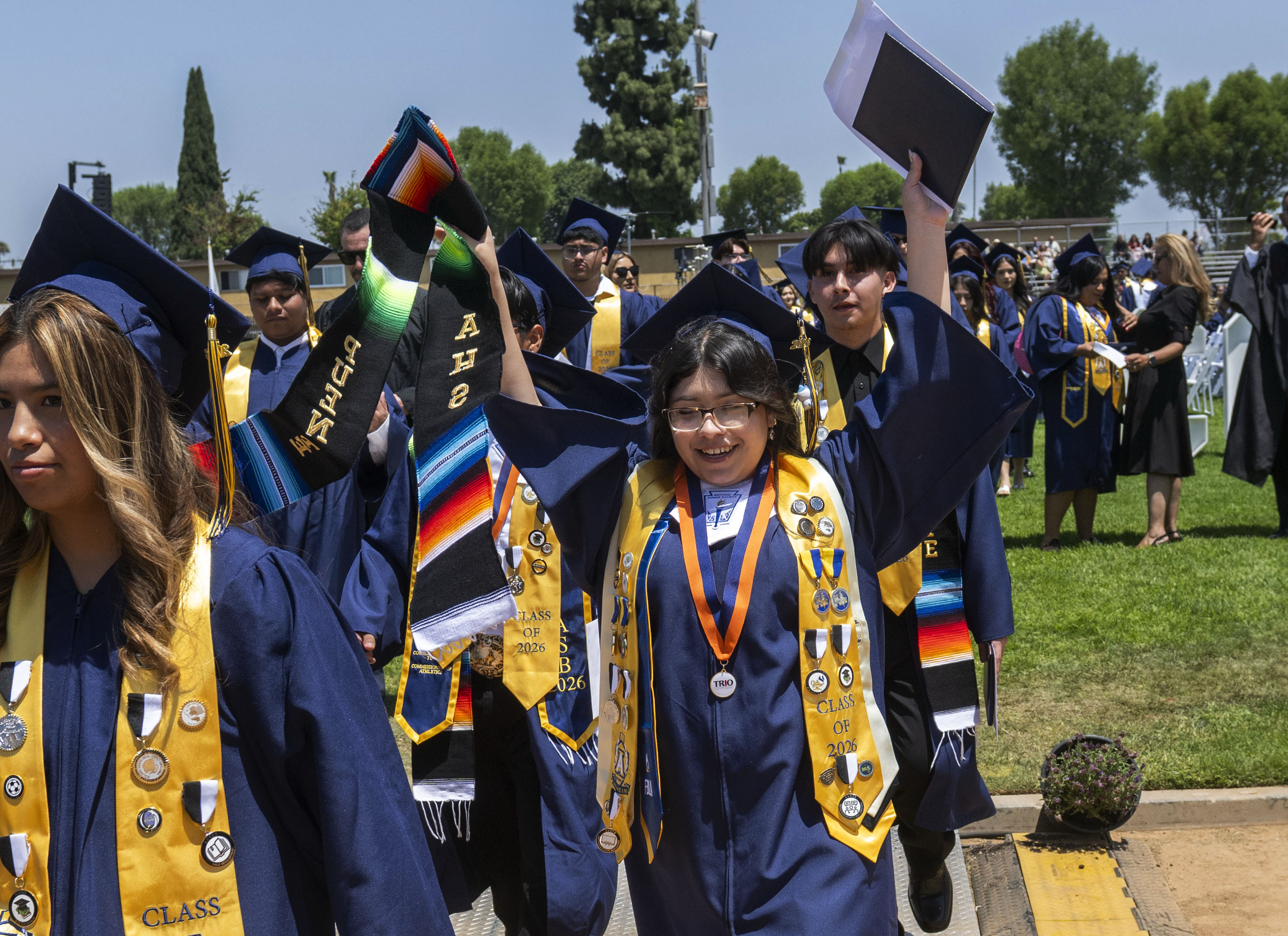 A happy graduate files out of Handel Stadium after the...