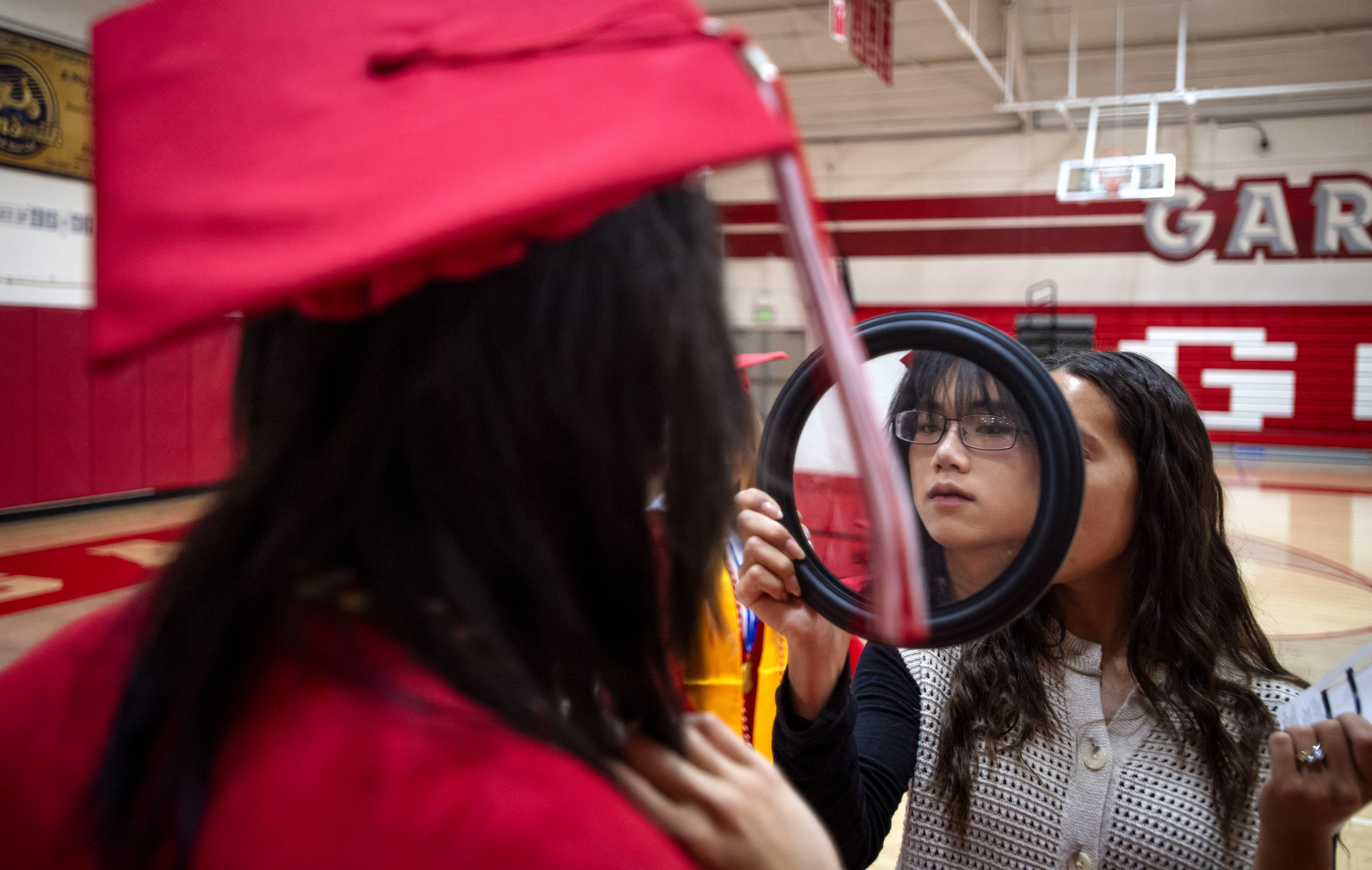 Julie OâBlenes holds a mirror so graduates could do some...