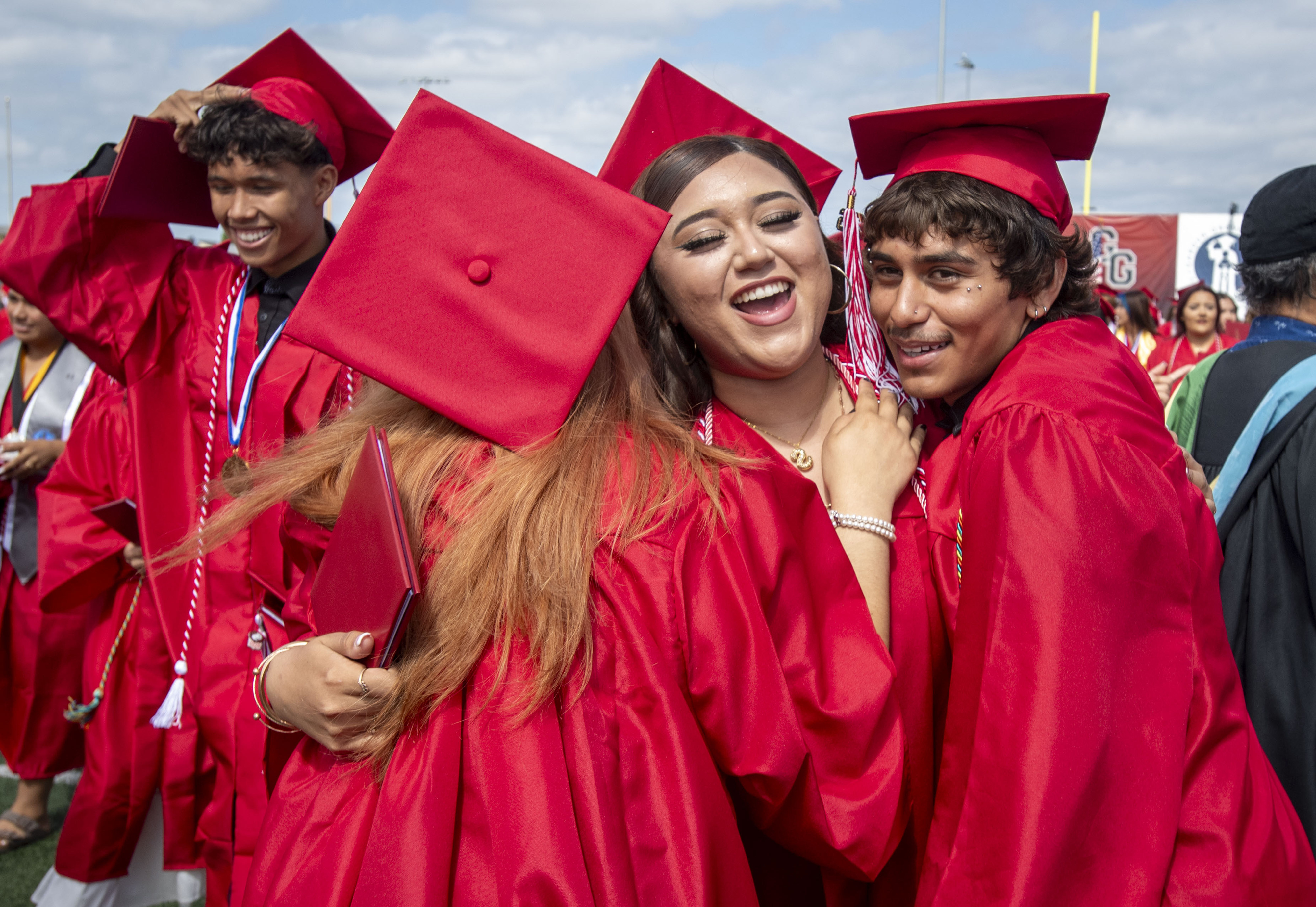 Friends have a group hug as graduates after the Garden...