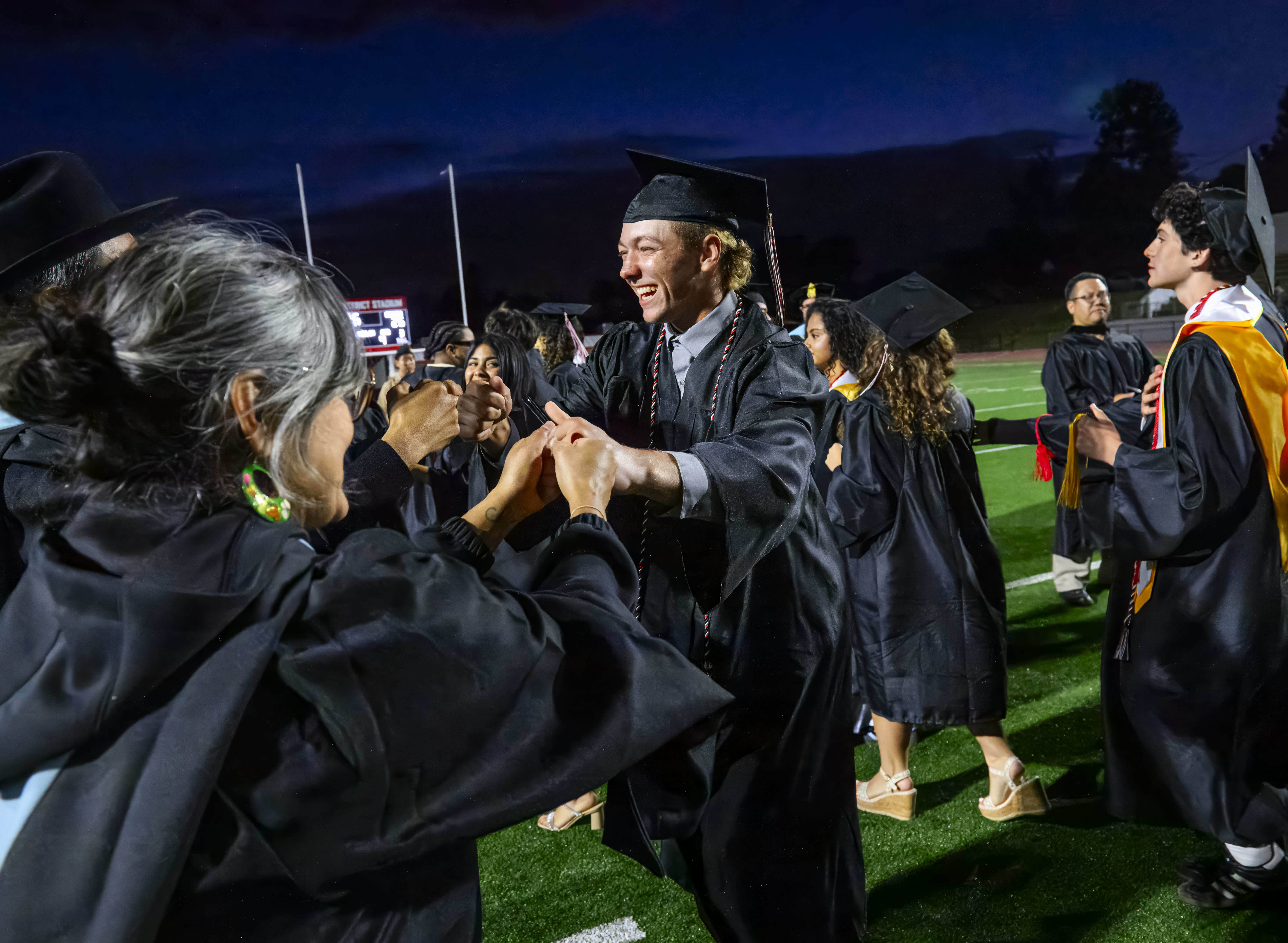 Graduate Mason Avey is congratulated by a teacher following the...