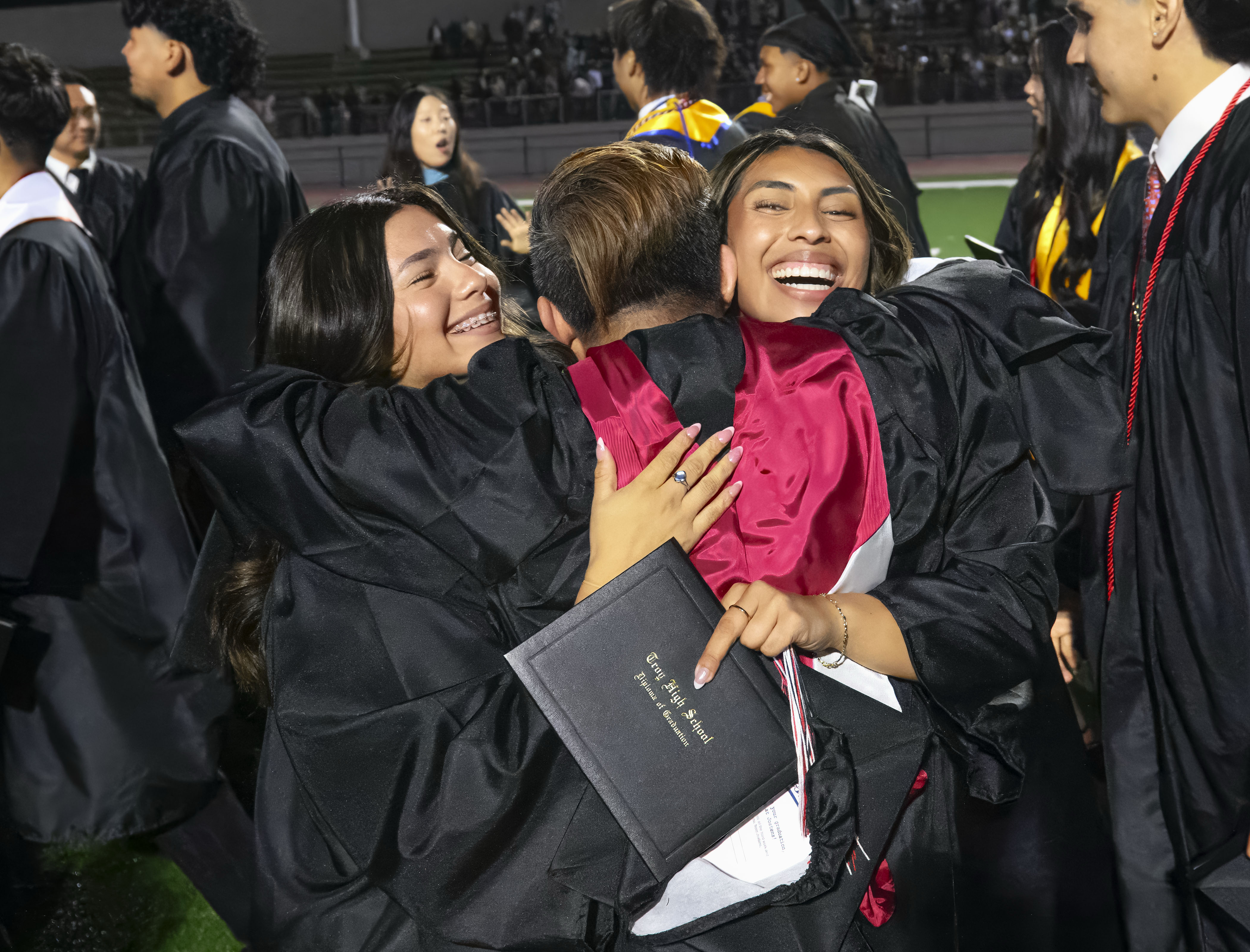 Graduate Liliana Banda, right, and a friend give a hug...