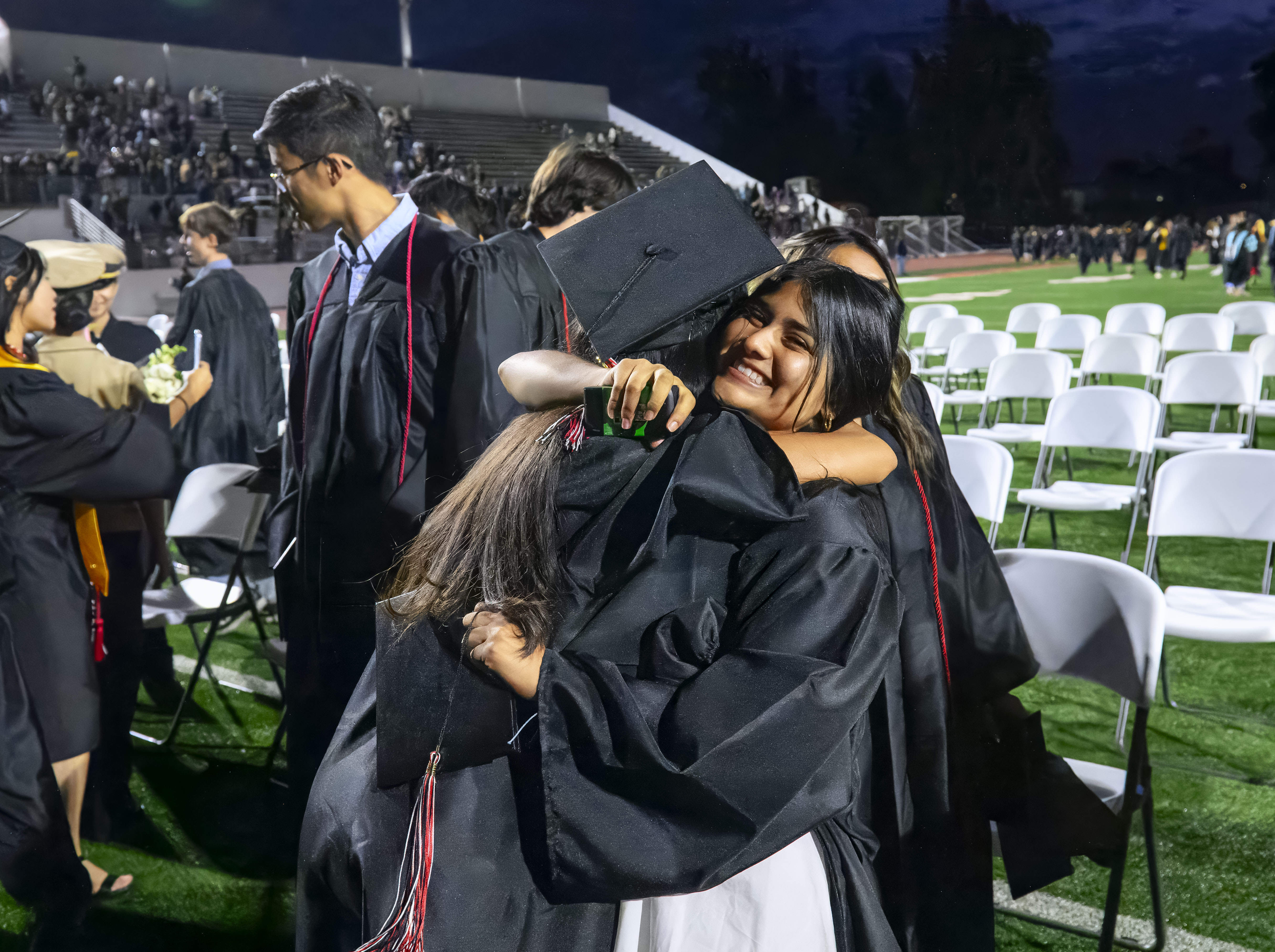 Graduate Nicole Cabañas-Mejia hugs another graduate to celebrate following the...