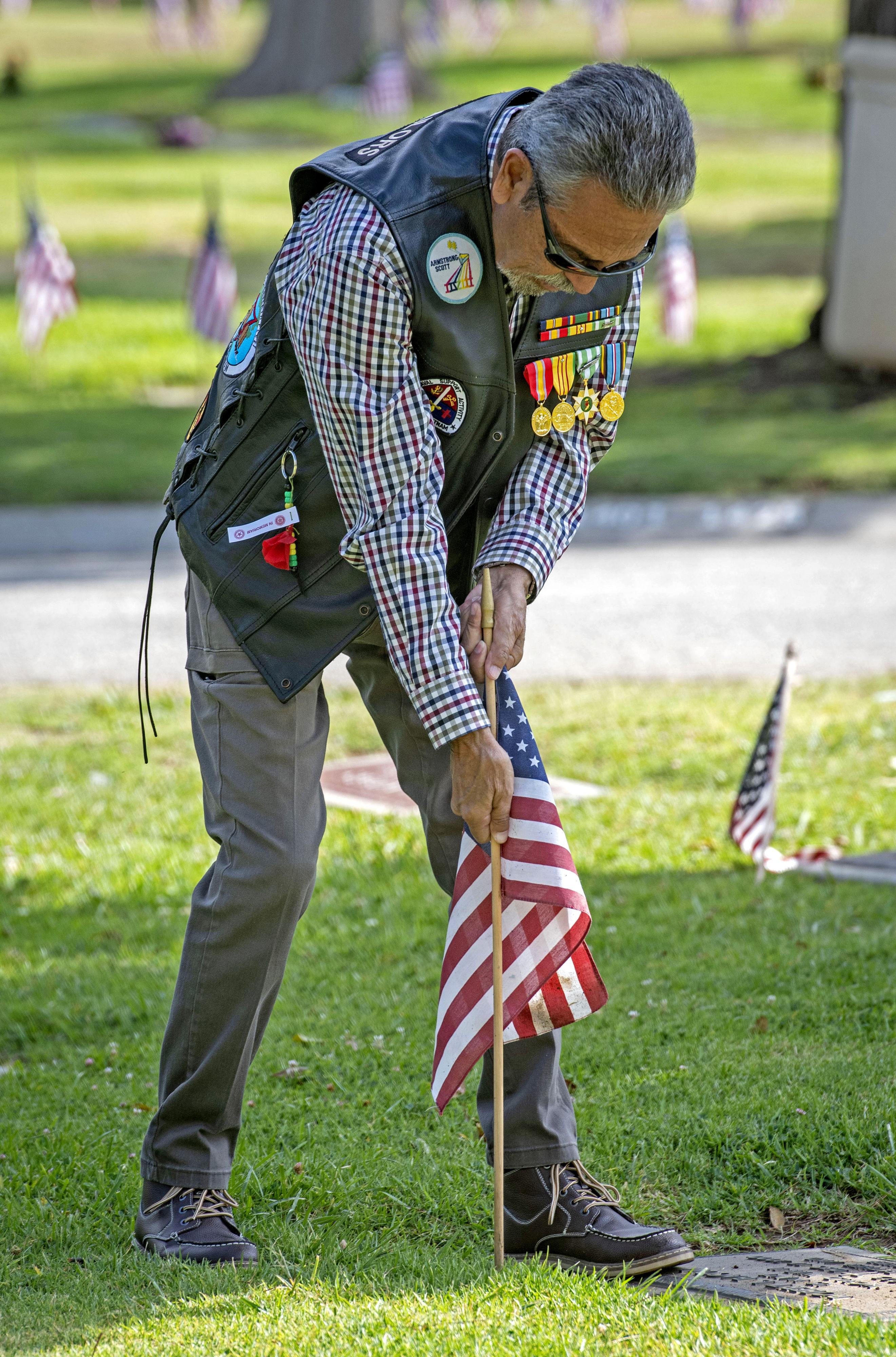 Vietnam War veteran Porfirio Duarte puts a flag into the...