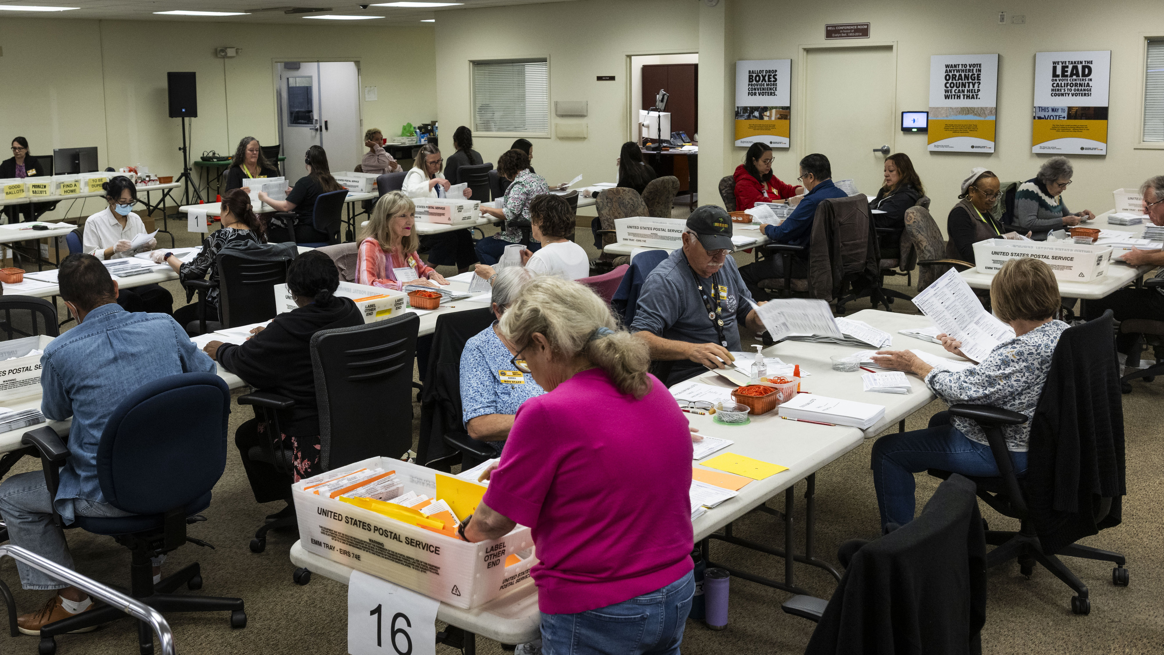 Workers take in ballots in the vote-by-mail processing area at...