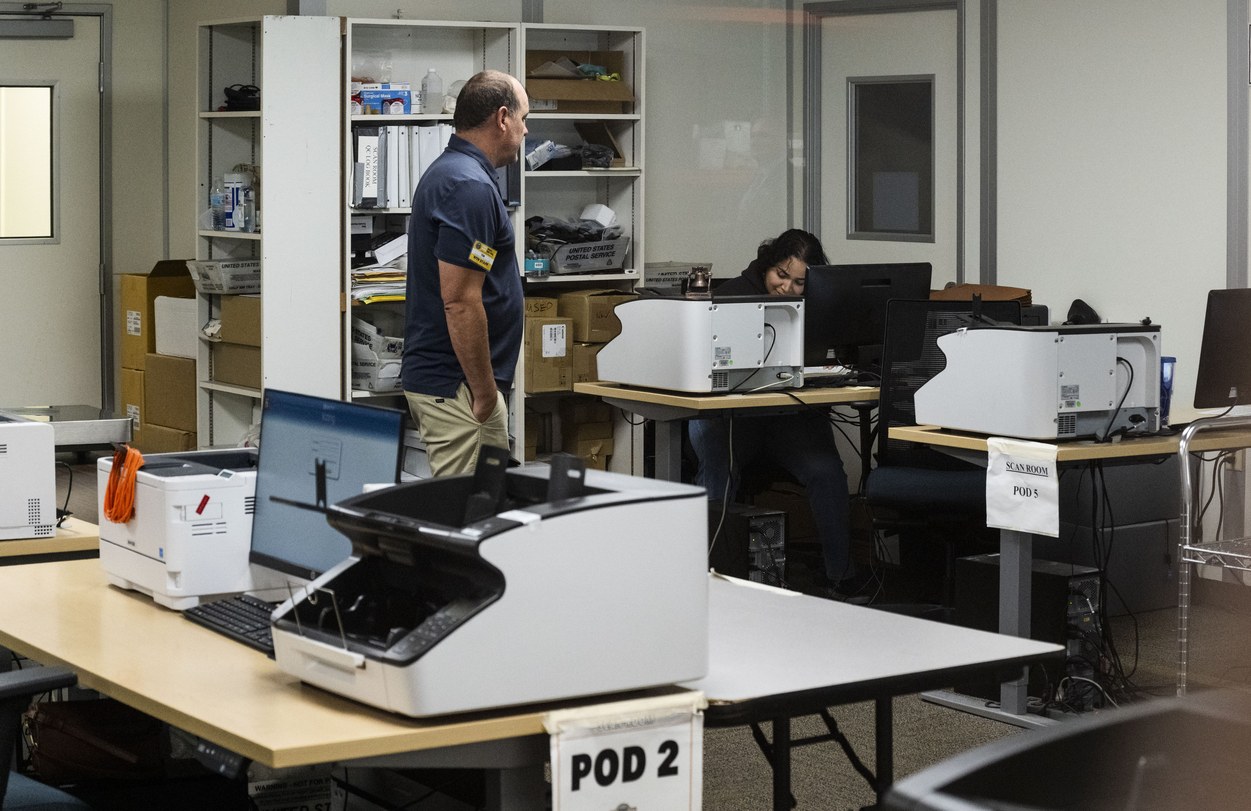 People work in ballot scanning at the Orange County Registrar...