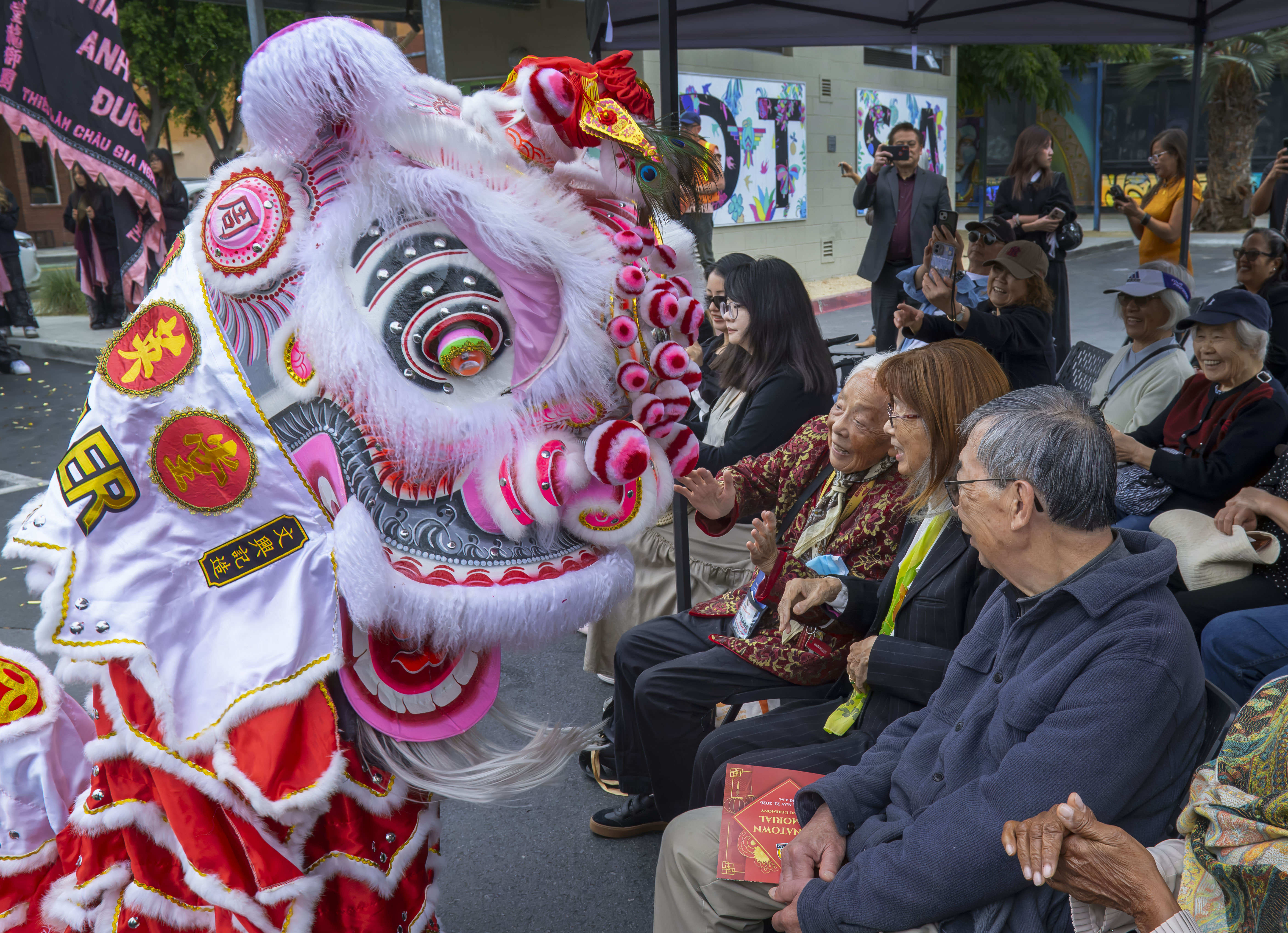 A lion dancer interacts with those attending the Chinatown Memorial...
