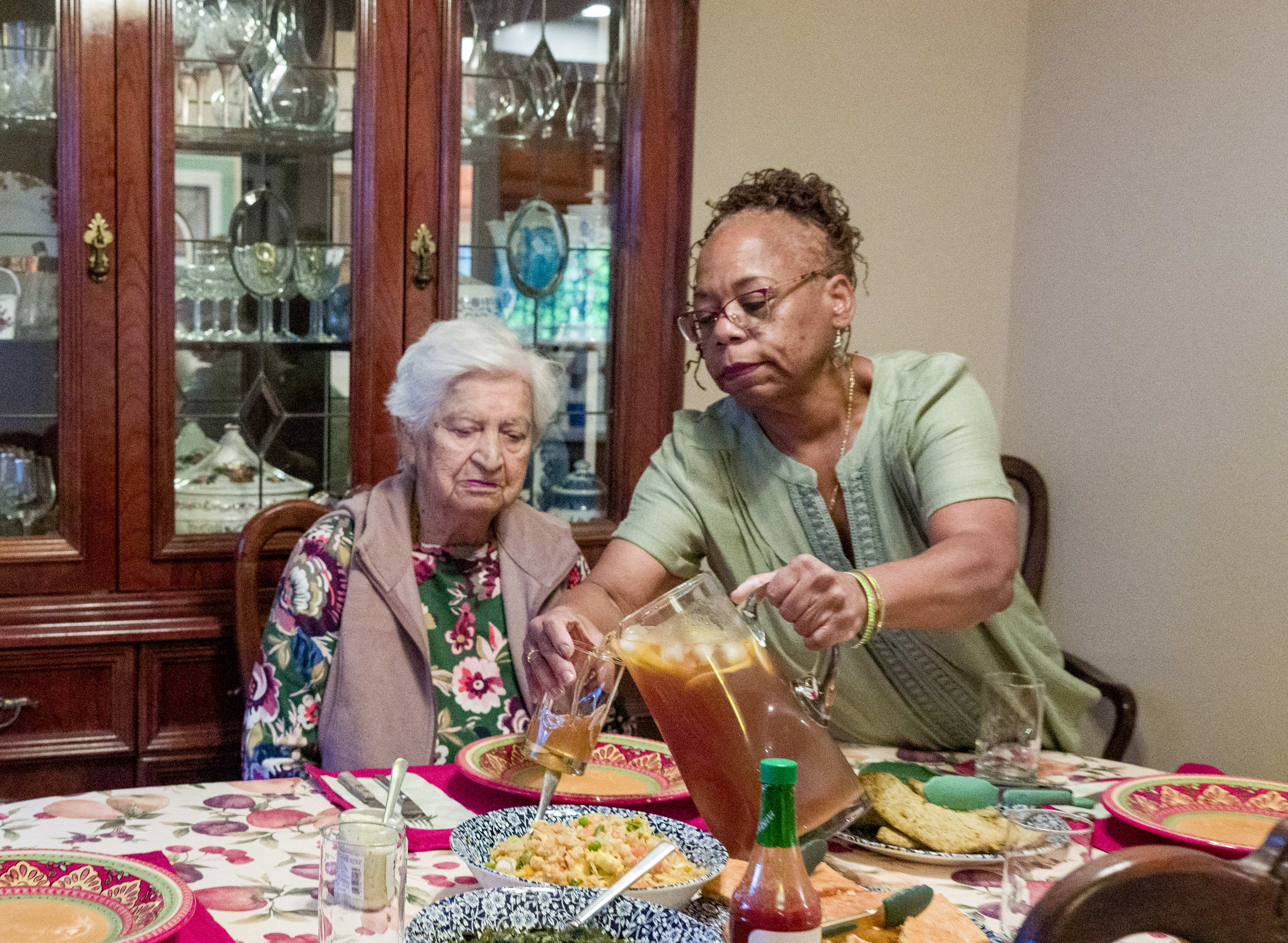 Darlene Hastings, right, pours tea for her elderly housemate, Ester...