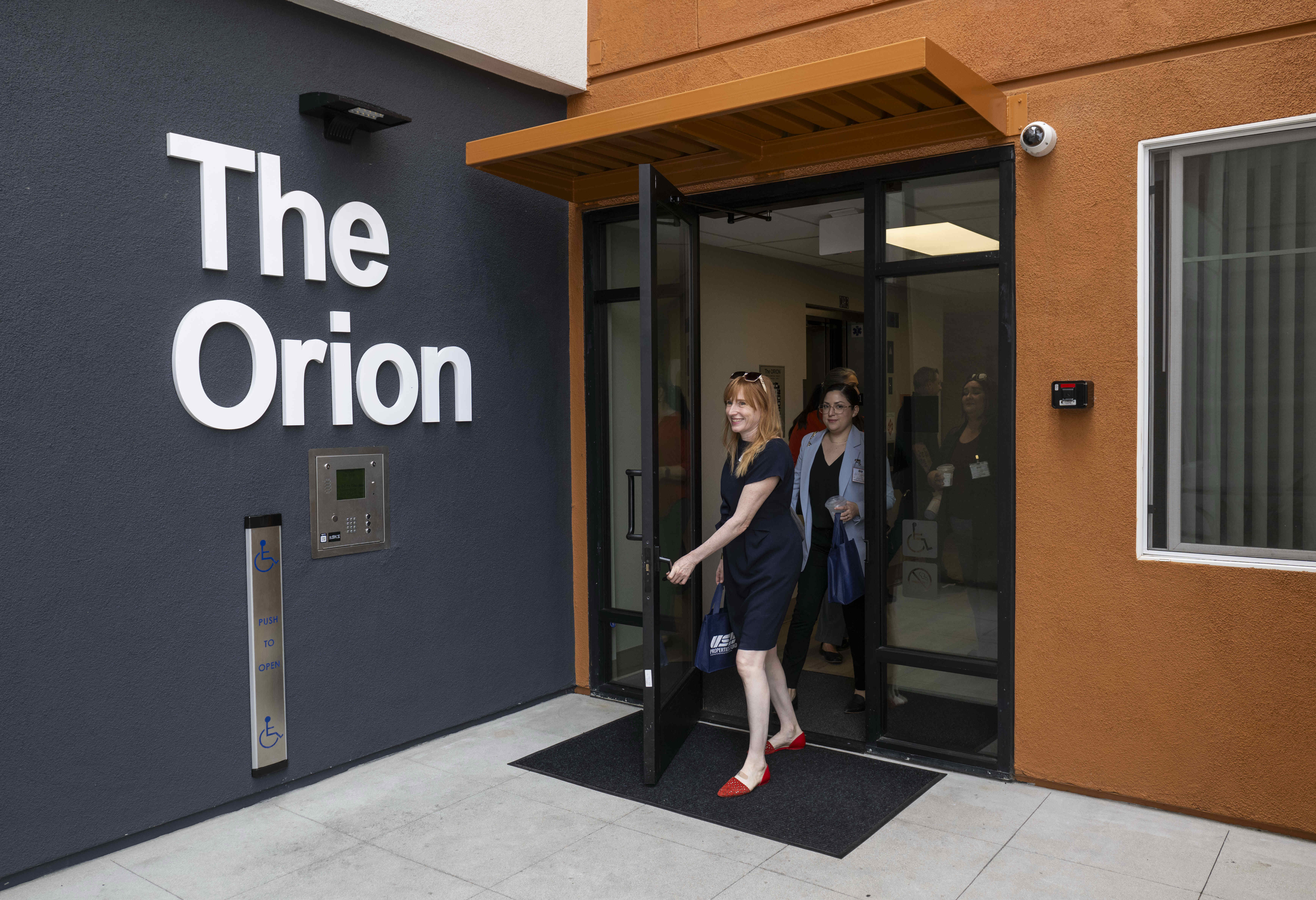 People tour The Orion low-income apartment community for residents 55...
