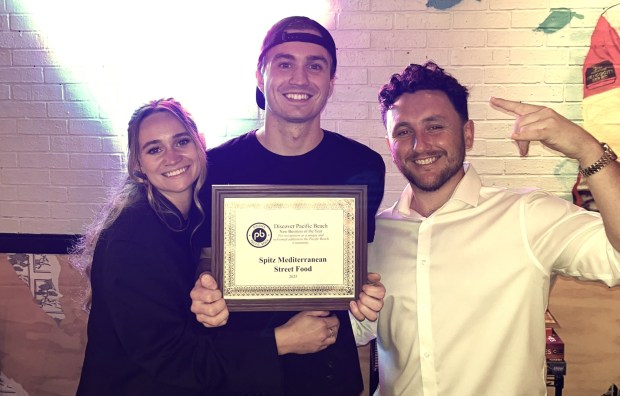 The Pacific Beach location of Spitz Mediterranean Restaurant is owned by Shealin Brennan-Law, Aidan Brennan-Law and Chris Burnthon. They are holding their award for "Best New Business in PB" presented by Discover PB in 2025. (Courtesy of Spitz Mediterranean)