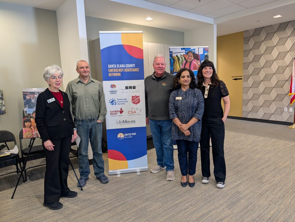 A group of people standing next to a sign
