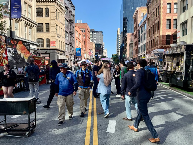 Crowd in street bordered by food trucks