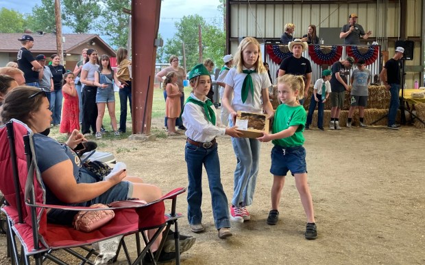 From left, Ari Houck, Mercy Ash and Lily Ash display a baked item at last year's Ramona Junior Fair Pie Auction. (Courtesy Kim Newcomer)