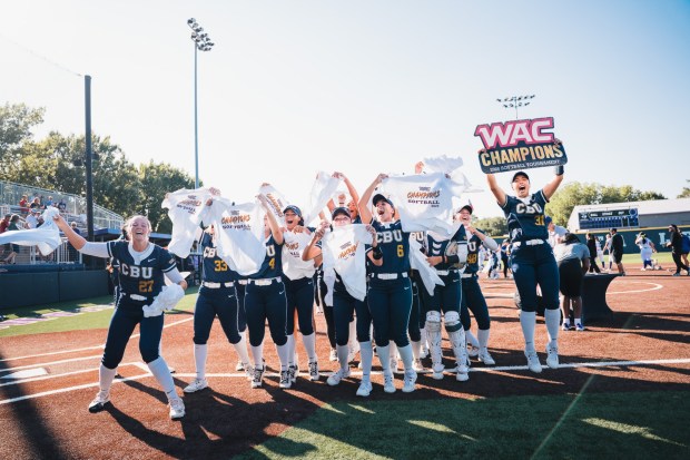 Victoria Macias, right, holds up the WAC Tournament Champions sign after the California Baptist University softball team defeated Tarleton State in the championship game.  (Courtesy of Matthew Horrocks, CBU Athletics)