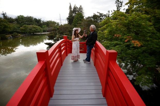Vanessa Trinh, left, from San Jose, and Rich Blakely, from Modesto, look at photos while standing on the Taiko Bashi Bridge at the Japanese Friendship Garden in Kelley Park in San Jose, Calif., on Monday, May 4, 2026. (Nhat V. Meyer/Bay Area News Group)