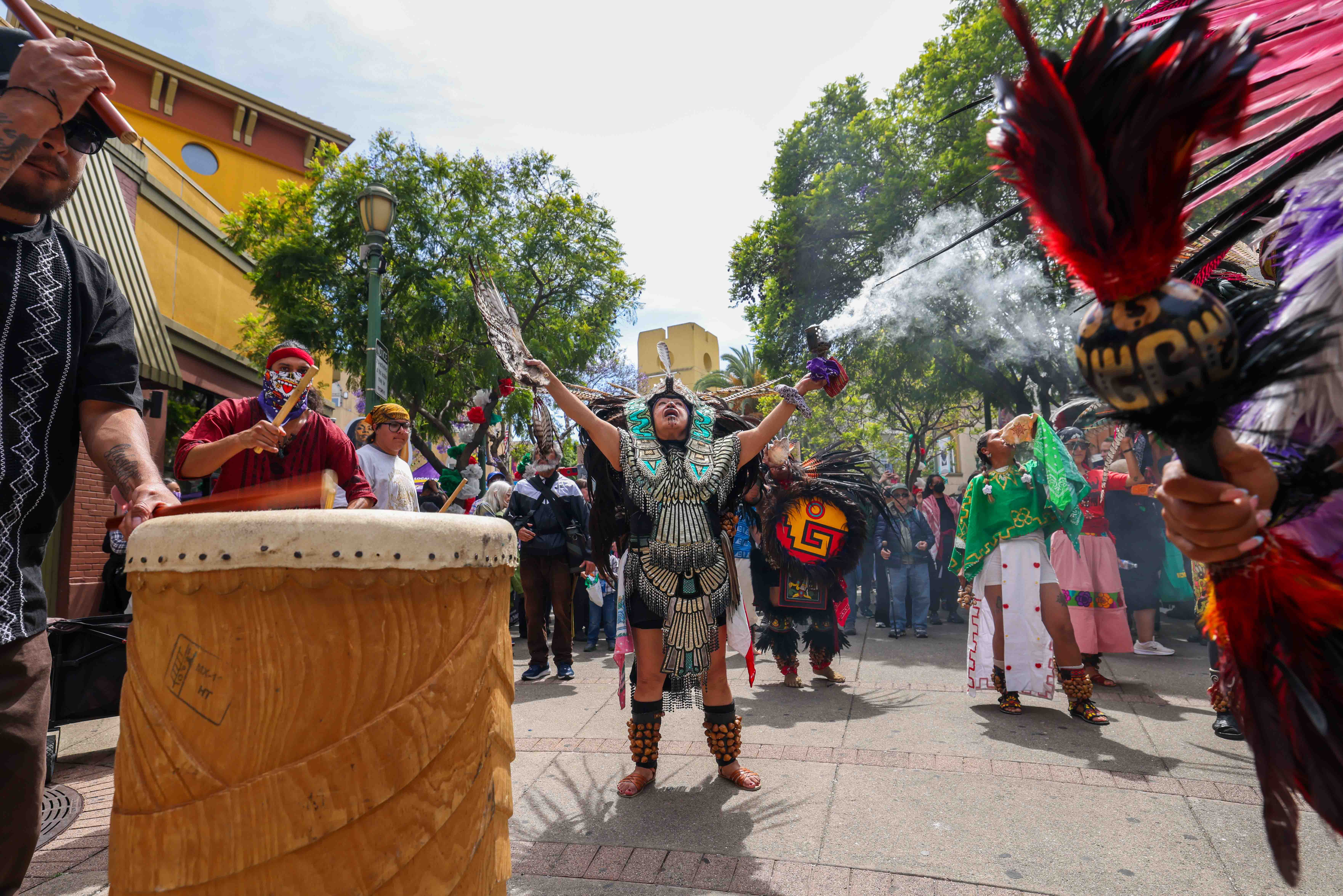 Aztec dancers take part in a May Day protest at...