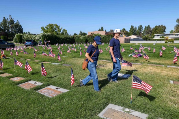 Assal Triolo and her son, Noah Triolo, 16, place American flags on the gravestones of fallen soldiers for Memorial Day weekend at Memory Garden Cemetery in Livermore, Calif., Saturday, May 23, 2026. About 120 mother-and-son teams from the Livermore chapter of the Young Men's Service League, in partnership with members of American Legion Post 47, took part in the annual event at Memory Garden Cemetery and St. Michael's Cemetery. (Ray Chavez/Bay Area News Group)