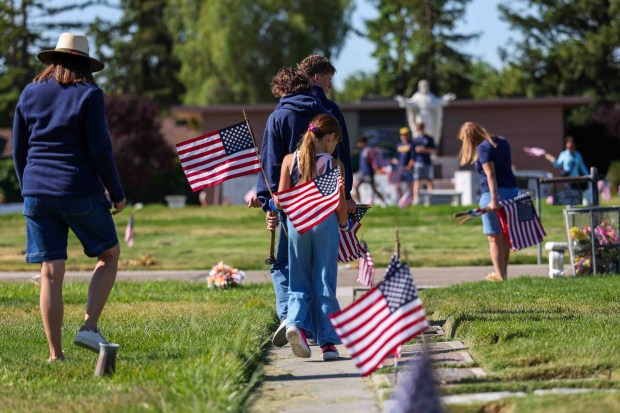 Daphne Eddy, 8, center, follows her mother, Rhiannon Eddy, and her brother, Grant, 13, as they place American flags on the gravestones of fallen soldiers for Memorial Day weekend at Memory Garden Cemetery in Livermore, Calif., Saturday, May 23, 2026. About 120 mother-and-son teams from the Livermore chapter of the Young Men's Service League, in partnership with members of American Legion Post 47, took part in the annual event at Memory Garden Cemetery and St. Michael's Cemetery. (Ray Chavez/Bay Area News Group)