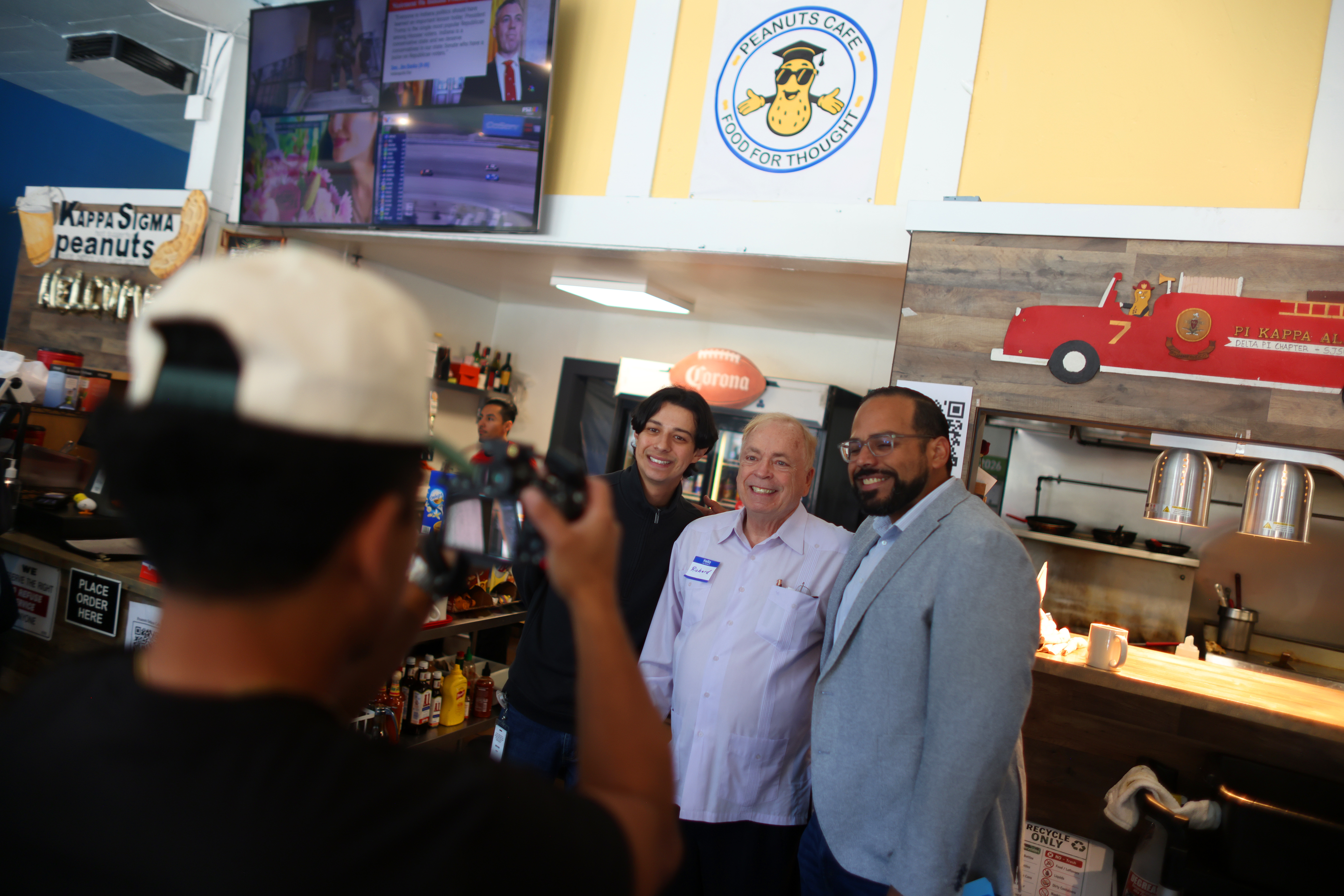 Peanuts Deluxe Cafe owner Richard Hobbs, center, poses for a...