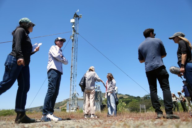 Officials and media members gather at the base of a tower holding a Whale Spotter thermal camera system on Angel Island on Tuesday, May 19, 2026 near San Francisco, Calif. (Aric Crabb/Bay Area News Group)