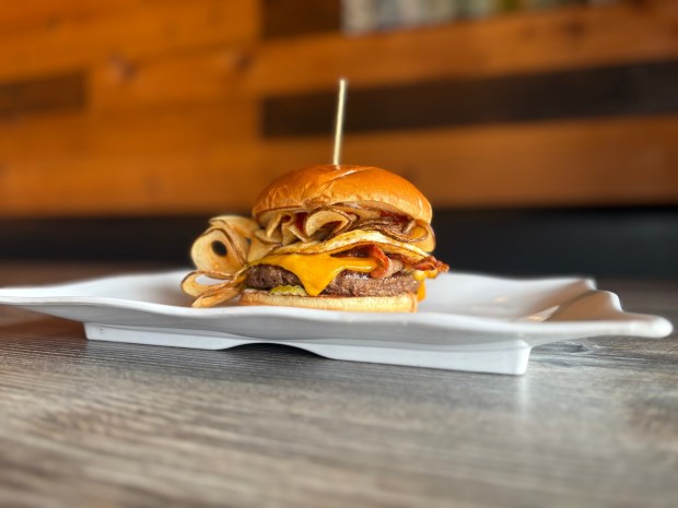 The Hangover Burger from Annys Burger is made with potato chips, bacon, swiss and cheddar cheese, a fried egg, pickles, ketchup and mayo. (Abby Hamblin / The San Diego Union-Tribune)