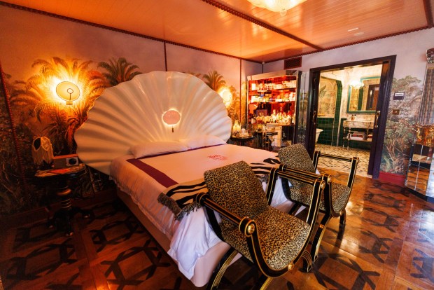 A guest room that utilizes an eclectic and Maximalist style inspired by the history of Coronado, features a clamshell bed and tropical wallpaper at The Baby Grand at Coronado on Thursday, May 7, 2026. (Kristian Carreon / The San Diego Union-Tribune)