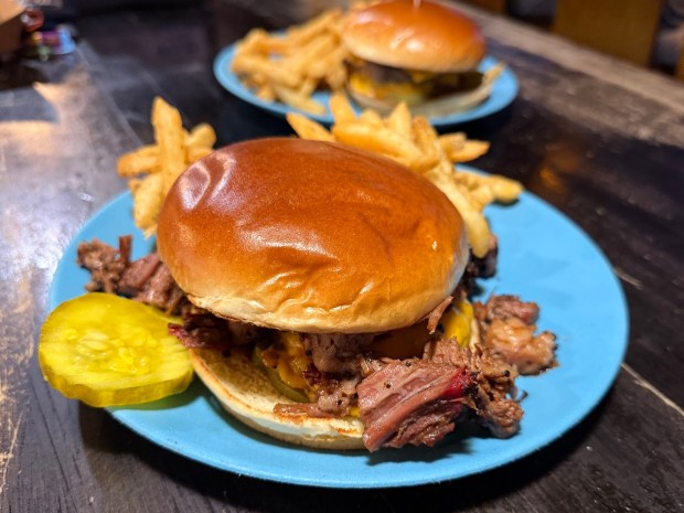 The Double Wide BBQ Burger at Grand Ole BBQ. Served with fries, this smash burger ups the ante with a topping of chopped brisket, sweet barbecue sauce and red onions. (Michael James Rocha / Union-Tribune)