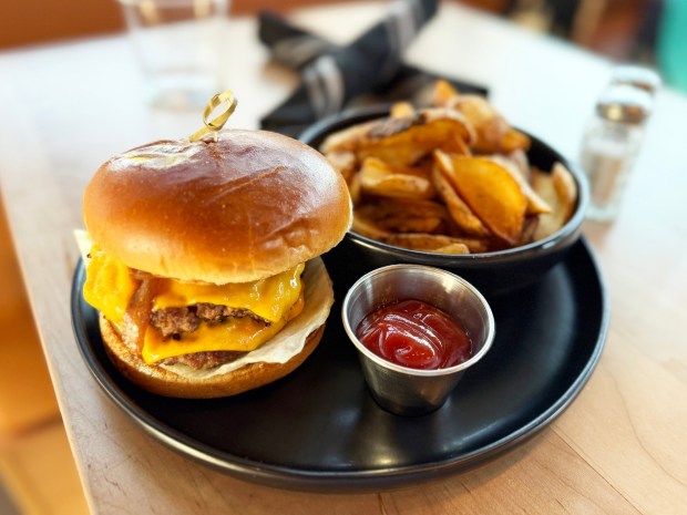 The Harland Smash Burger features two smashed beef patties tucked in between a delicious brioche bun. It comes with American cheese, caramelized onions, pickles, lettuce, tomato and the house special sauce. (Michael James Rocha / Union-Tribune)