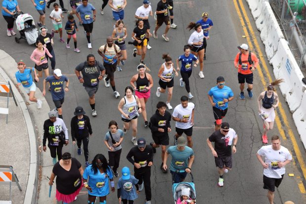 SAN DIEGO, CA - May 18, 2025: Runners turn on to Harbor Drive from the start line on Park Boulevard in downtown San Diego as more than 10,000 people participate in the Navy's 38th Bay Bridge Run/Walk, a four mile course that goes through Barrio Logan, over the Coronado Bridge, ending at Coronado Tidelands Park on Sunday, May 18, 2025. (Hayne Palmour IV / For The San Diego Union-Tribune)