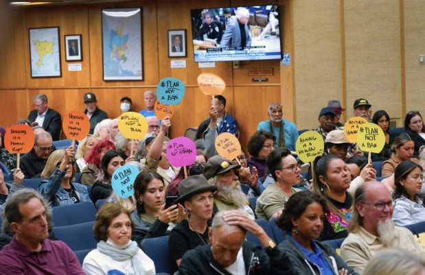 People hold signs in opposition to San Diego's encampment ban ahead of a vote by the San Diego City Council on Tuesday, June 13, 2023. (Nelvin C. Cepeda / The San Diego Union-Tribune)