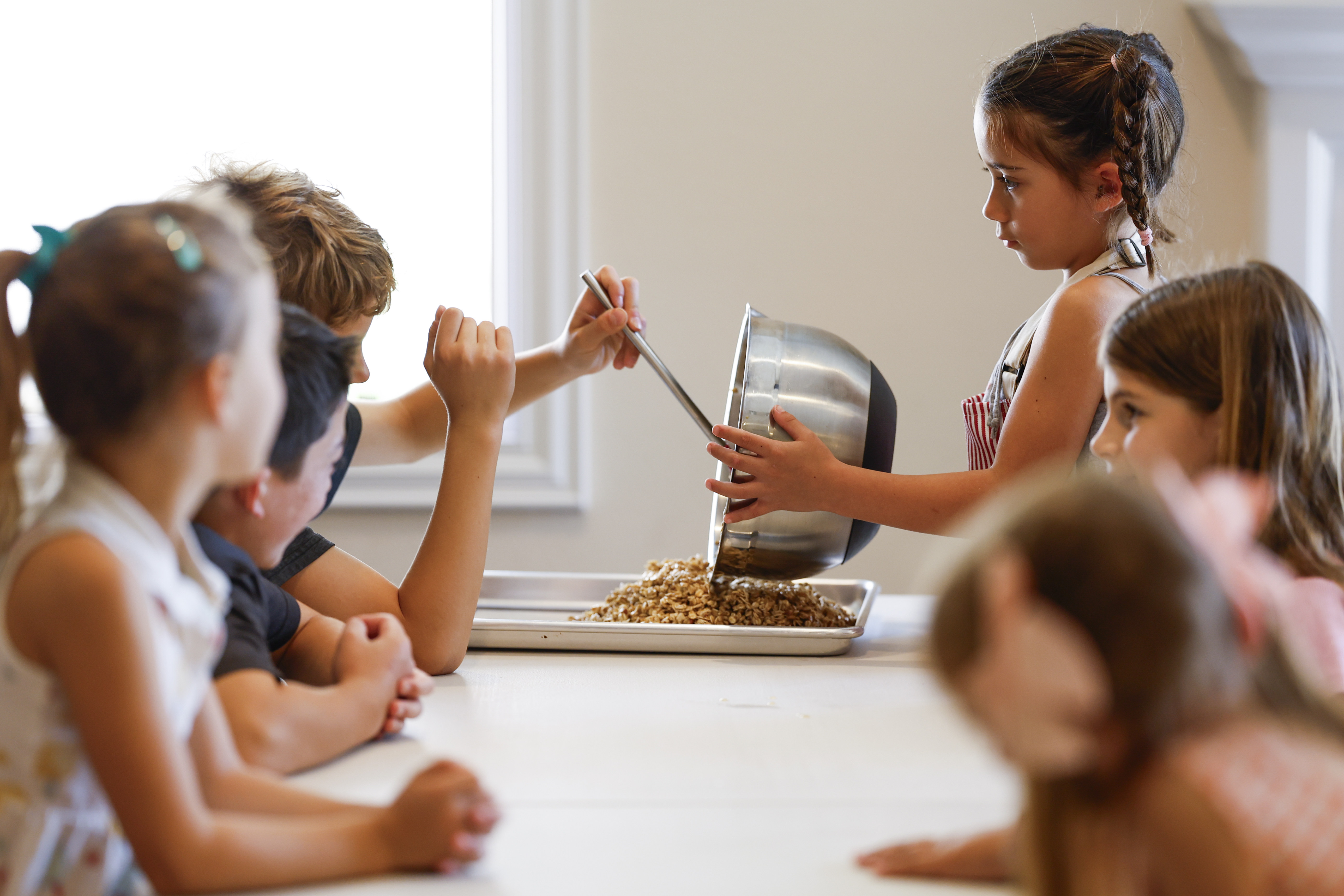 Taylor Waddon, 6, steadies the mixing bowl of granola as...