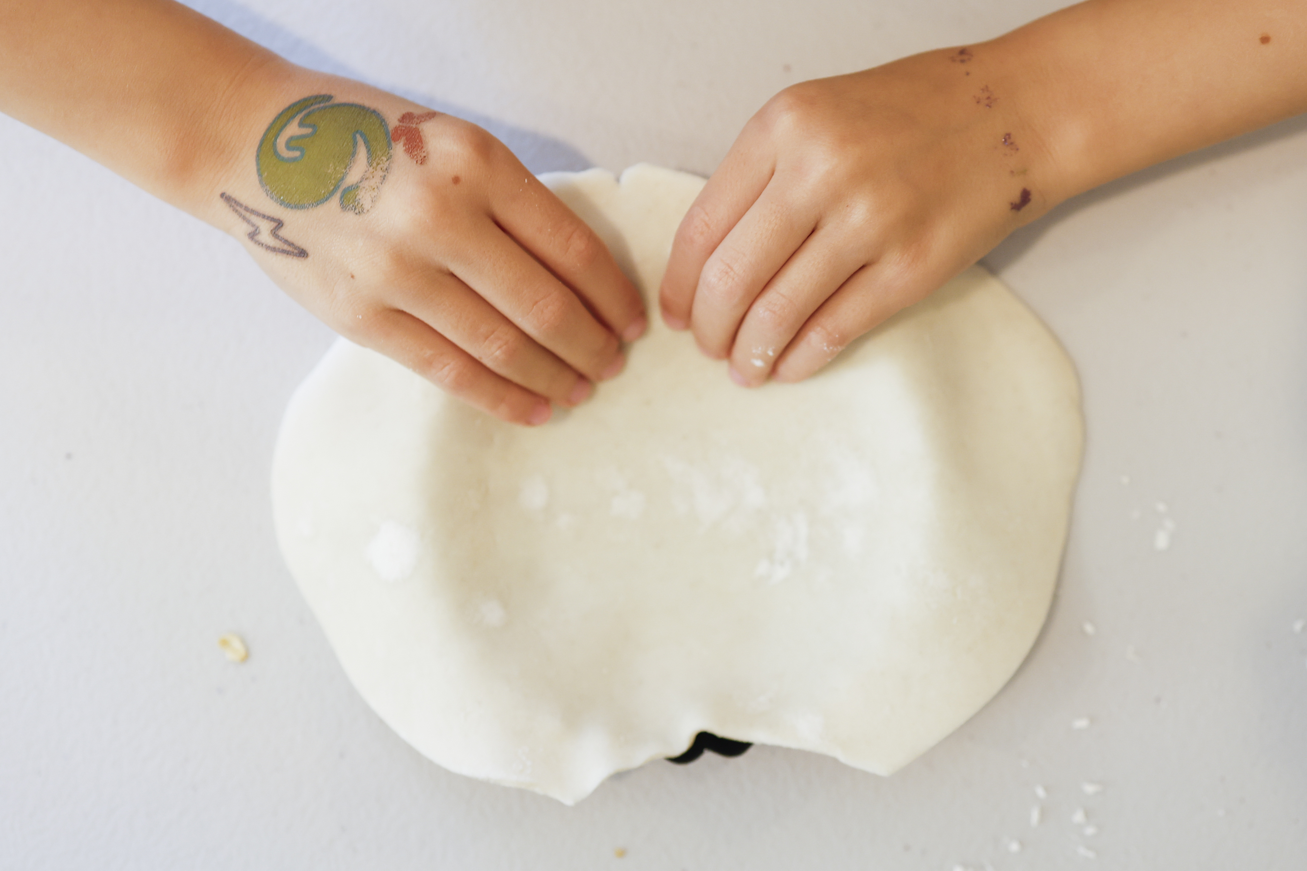 Gina Kathman, 6, of Del Mar, works the dough of...