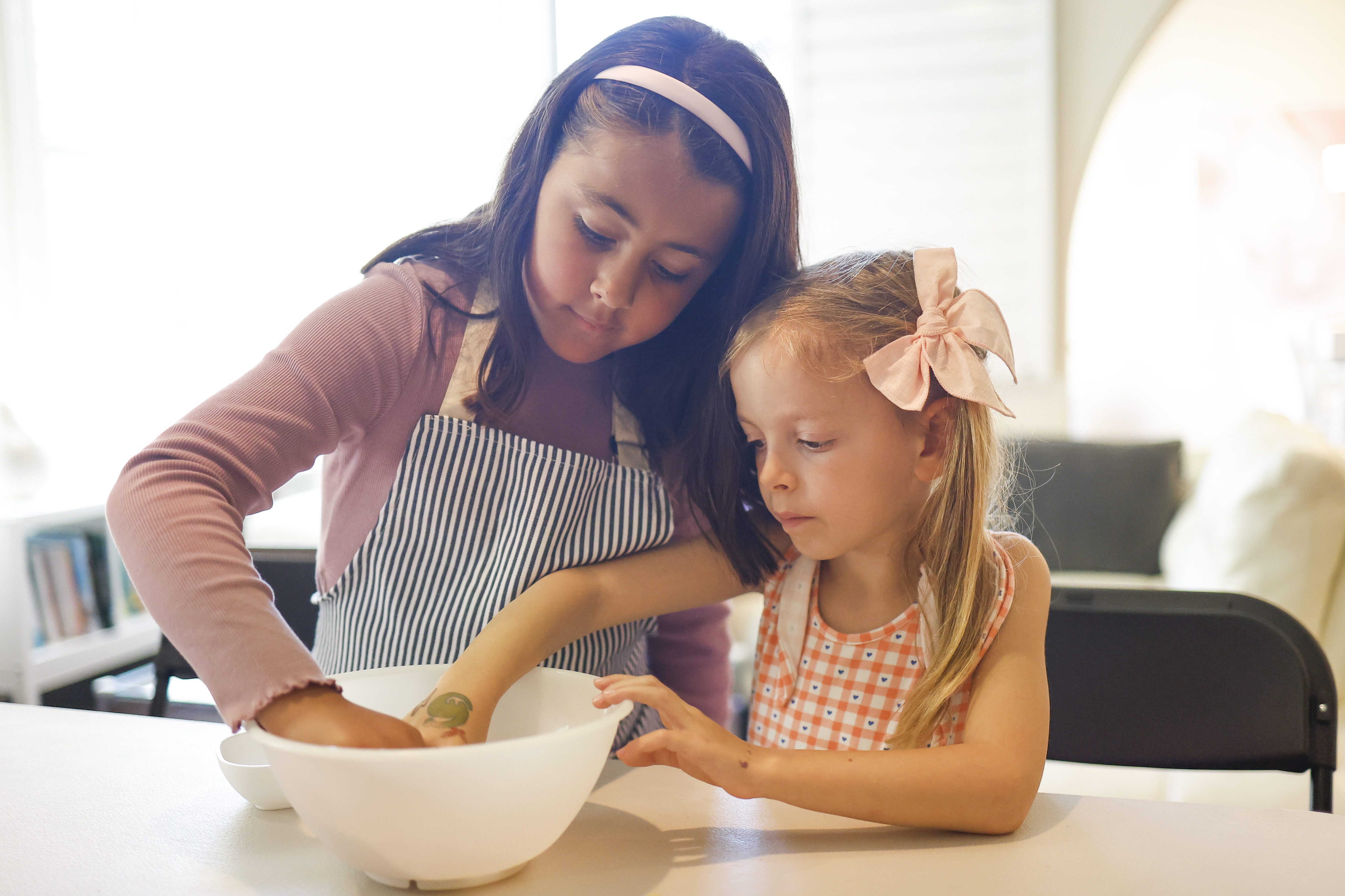 Aileen Ramos, 7, and Gina Kathman, 6, use a team...
