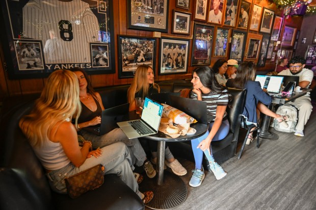 People work on their laptops during a remote work event organized by Scott Muirhead held at The Cardiff Office bar April 24, 2026 in Encinitas, Calif. (Photo by Denis Poroy)