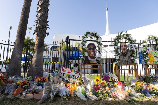 Flowers are laid against the fence in a memorial at the Islamic Center of San Diego on Friday. (Luke Johnson / The San Diego Union-Tribune)