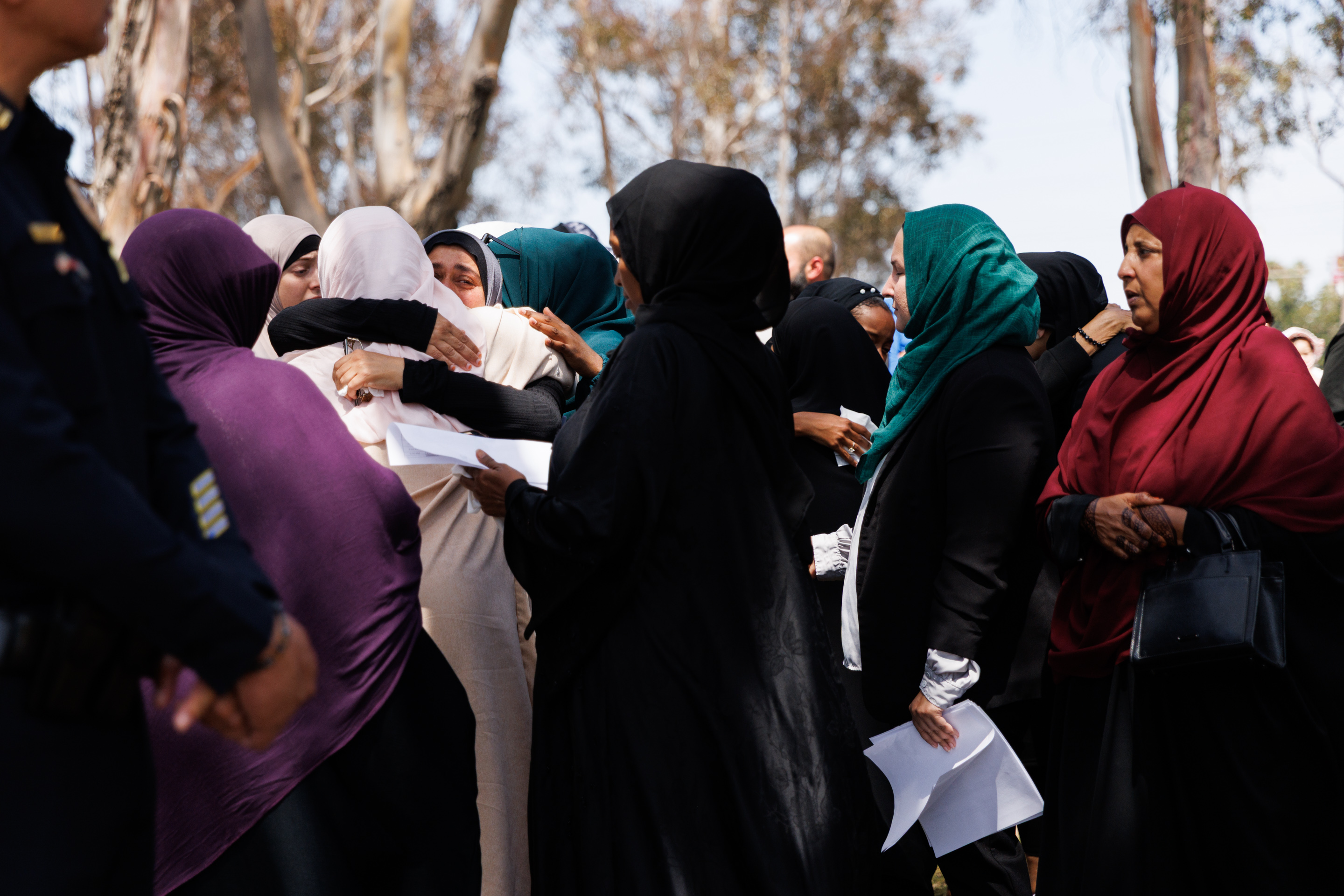 People embrace during a press conference on the shooting at...