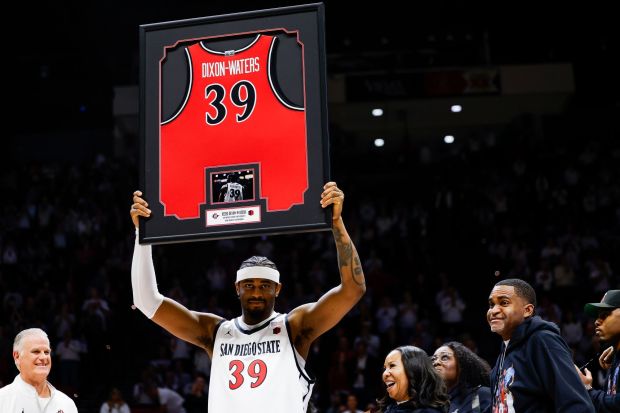 SDSU guard Reese Dixon-Waters holds up a framed jersey on Senior Night before the Aztecs' game against UNLV on March 6. (Meg McLaughlin / The San Diego Union-Tribune)