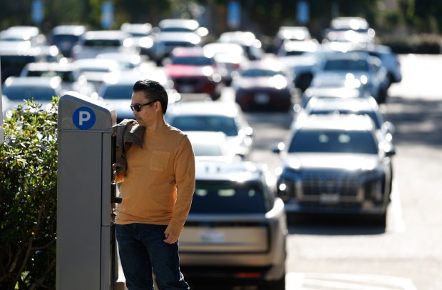 A visitor uses a parking meter in Ballboa Park on Jan. 26, 2026. The city recently implemented paid parking in the park. (K.C. Alfred / The San Diego Union-Tribune) 