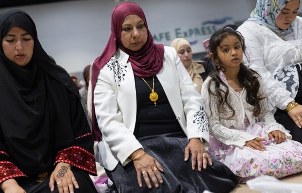 San Diego, CA - Tazheen Nizam of San Diego Council on American-Islamic Relations (CAIR), in red, prays as community members come together during the Islamic holiday Eid al-Adha at the San Diego Convention Center on Wednesday, May 27, 2026, in San Diego, CA. The community is coming together to heal during the "Festival of Sacrifice" nine days after the Islamic Center of San Diego was the target of a shooting. (Luke Johnson / The San Diego Union-Tribune)