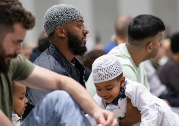 San Diego, CA - A man who asked to not be named , but consented to the use of his photograph, holds his children as community members come together to pray during the Islamic holiday Eid al-Adha at the San Diego Convention Center on Wednesday, May 27, 2026, in San Diego, CA. The community is coming together to heal during the "Festival of Sacrifice" nine days after the Islamic Center of San Diego was the target of a shooting. (Luke Johnson / The San Diego Union-Tribune)