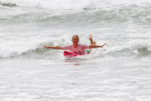 Coral McIntyre, 18, is all smiles as she belly rides a wave in after competing in her heat at the 10th annual OB Pier Surf and Skate Classic at Ocean Beach on Saturday, May 2, 2026. (Kristian Carreon / The San Diego Union-Tribune)