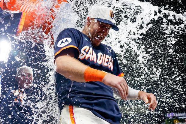 Jackson Merrill #3 and Ty France #25 douse Gavin Sheets #30 of the San Diego Padres in sports drink after his walk-off homer against the Colorado Rockies during the ninth inning at Petco Park on Friday, April 10, 2026 in San Diego, California. (Meg McLaughlin / The San Diego Union-Tribune)