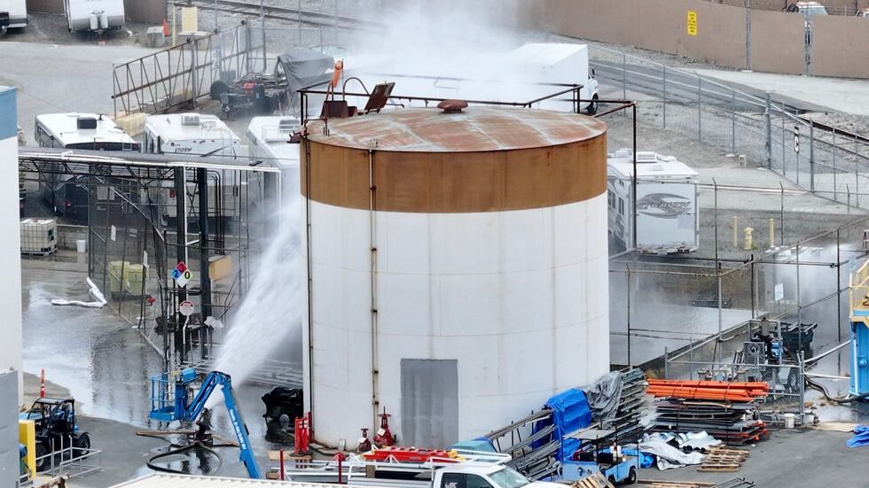 Water is sprayed on a tank that overheated at an aerospace plant in Garden Grove, Calif.,...