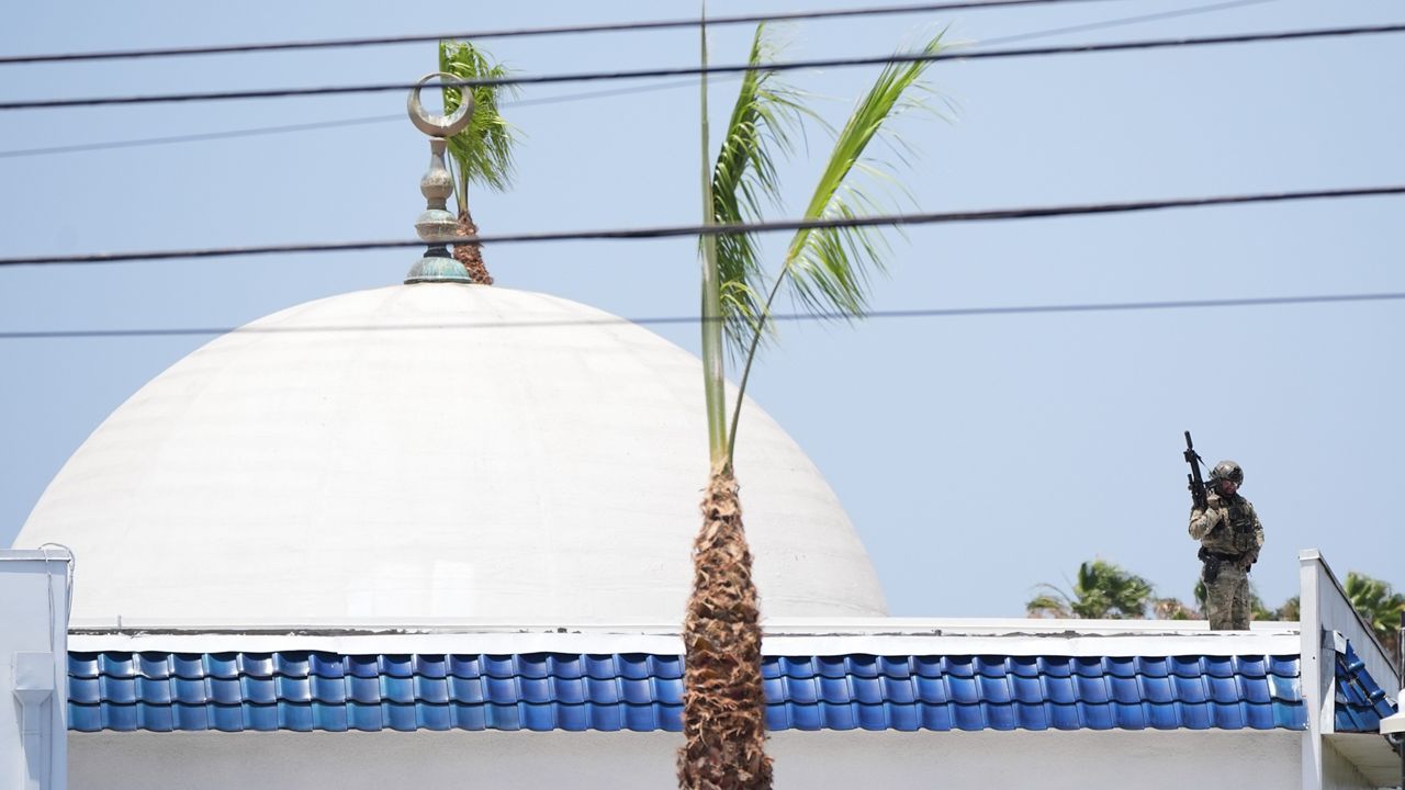 Police stage on a roof at the scene of a shooting outside the Islamic Center of San Diego Monday, May 18, 2026, in San Diego. (AP Photo/Gregory Bull)