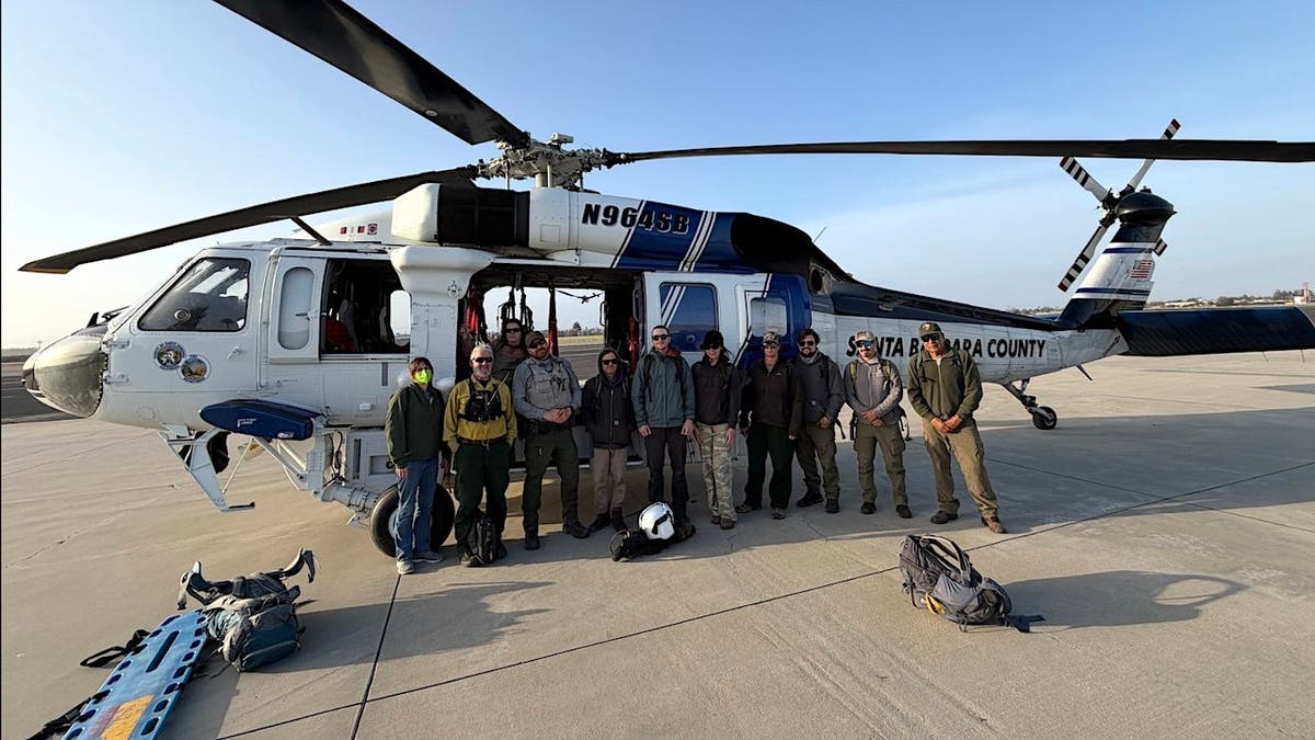 a helicopter with fire rescuse workers posing after saving 11 park employees