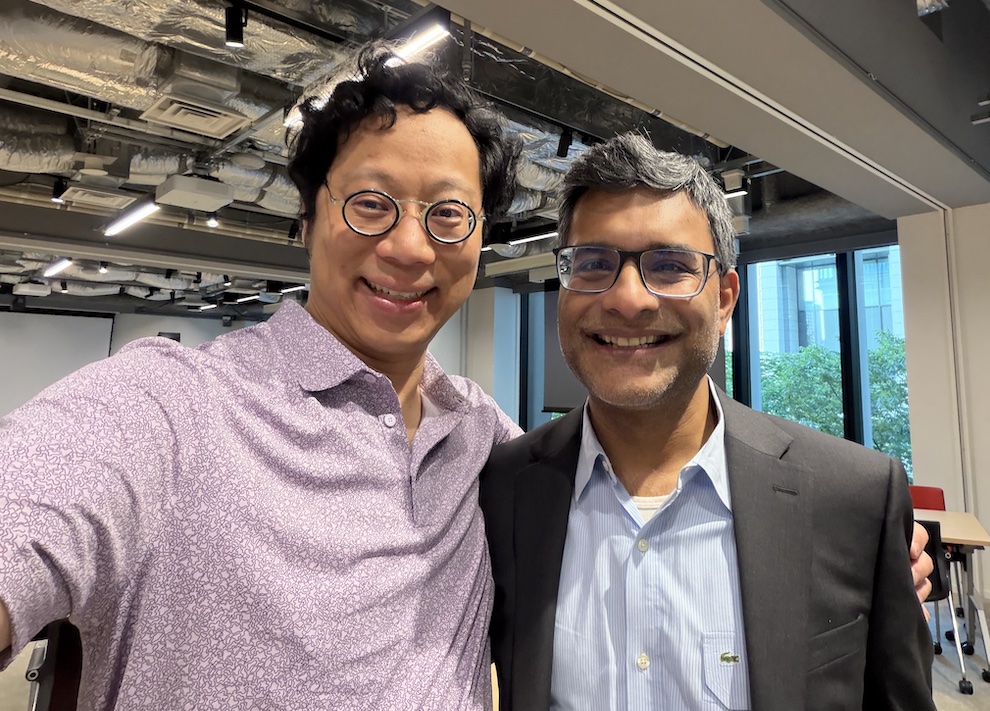 two men in work attire, both wearing glasses