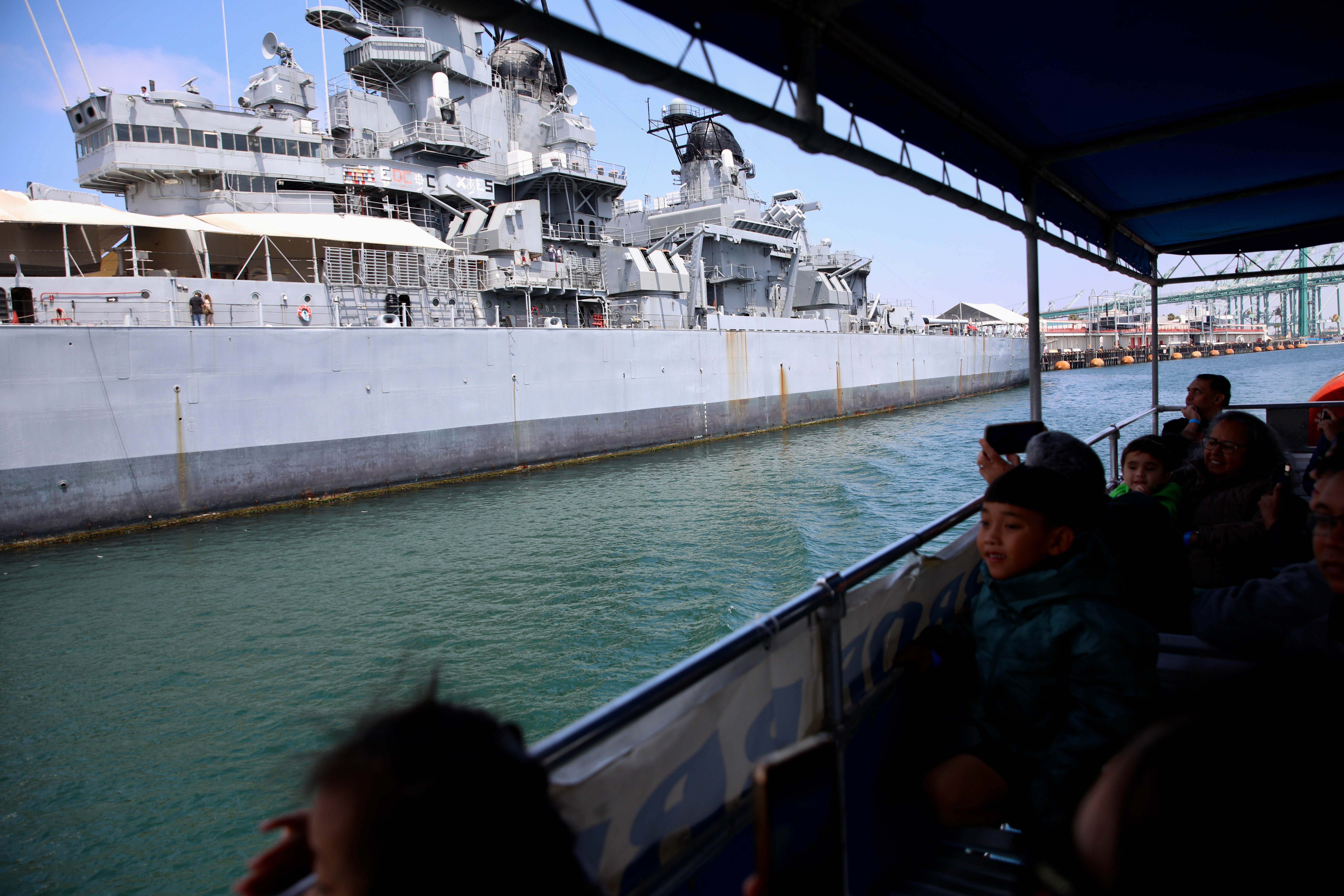 Passengers pull out their cameras for the Battleship Iowa during...