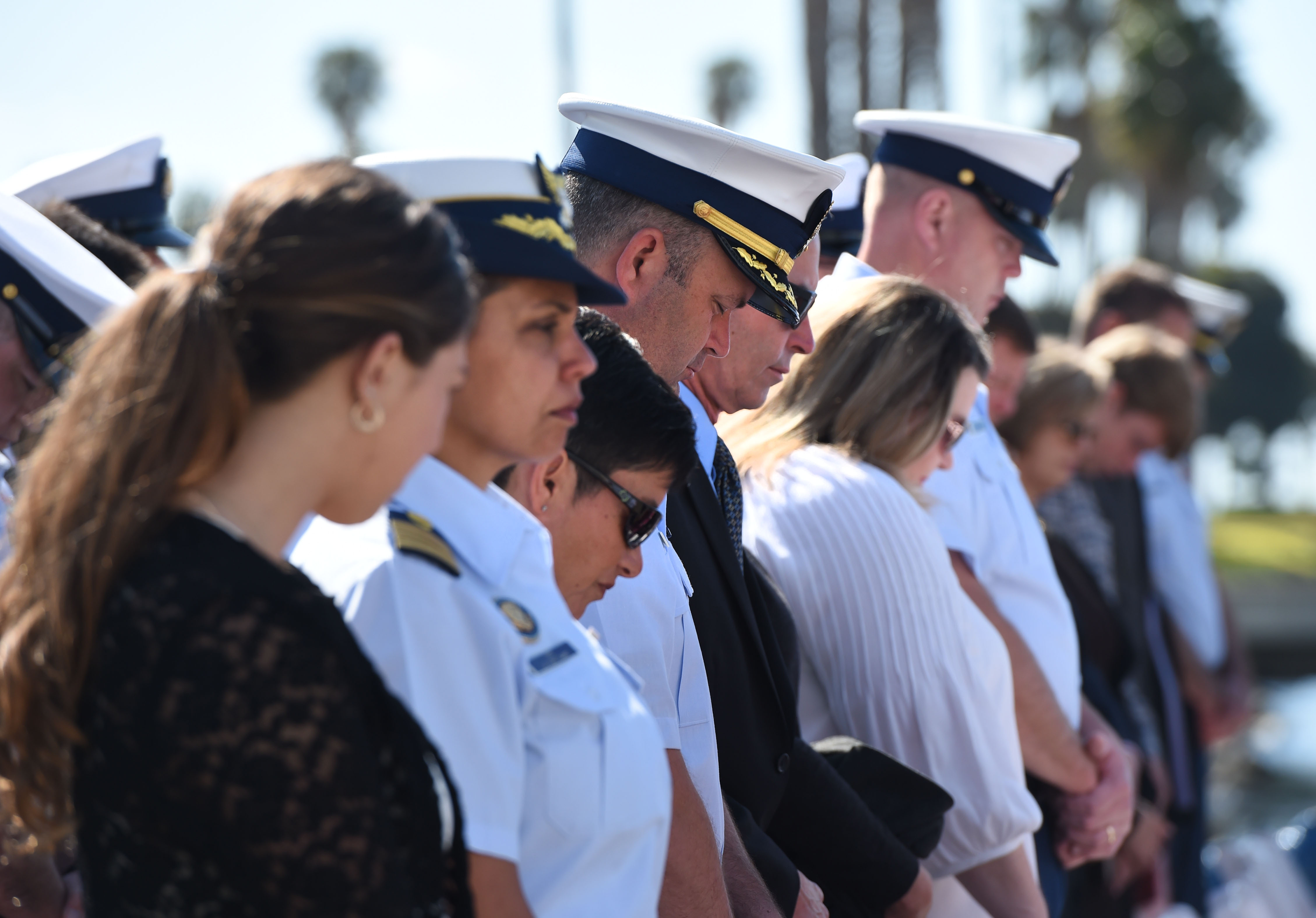The audience bows their head in prayer during the commissioning...