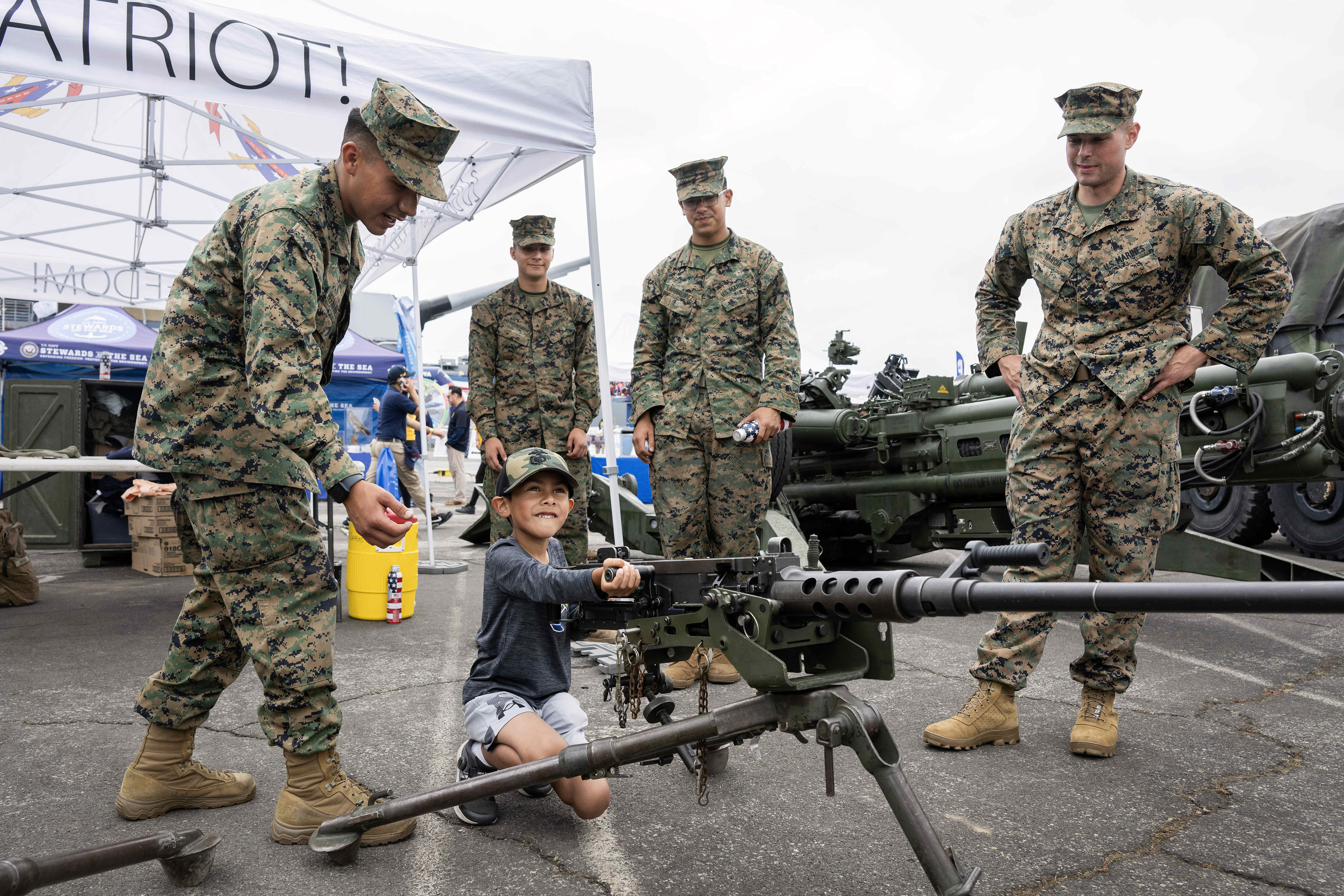 Seven-year-old Roman Ruiz poses for a photograph with an M2A1...