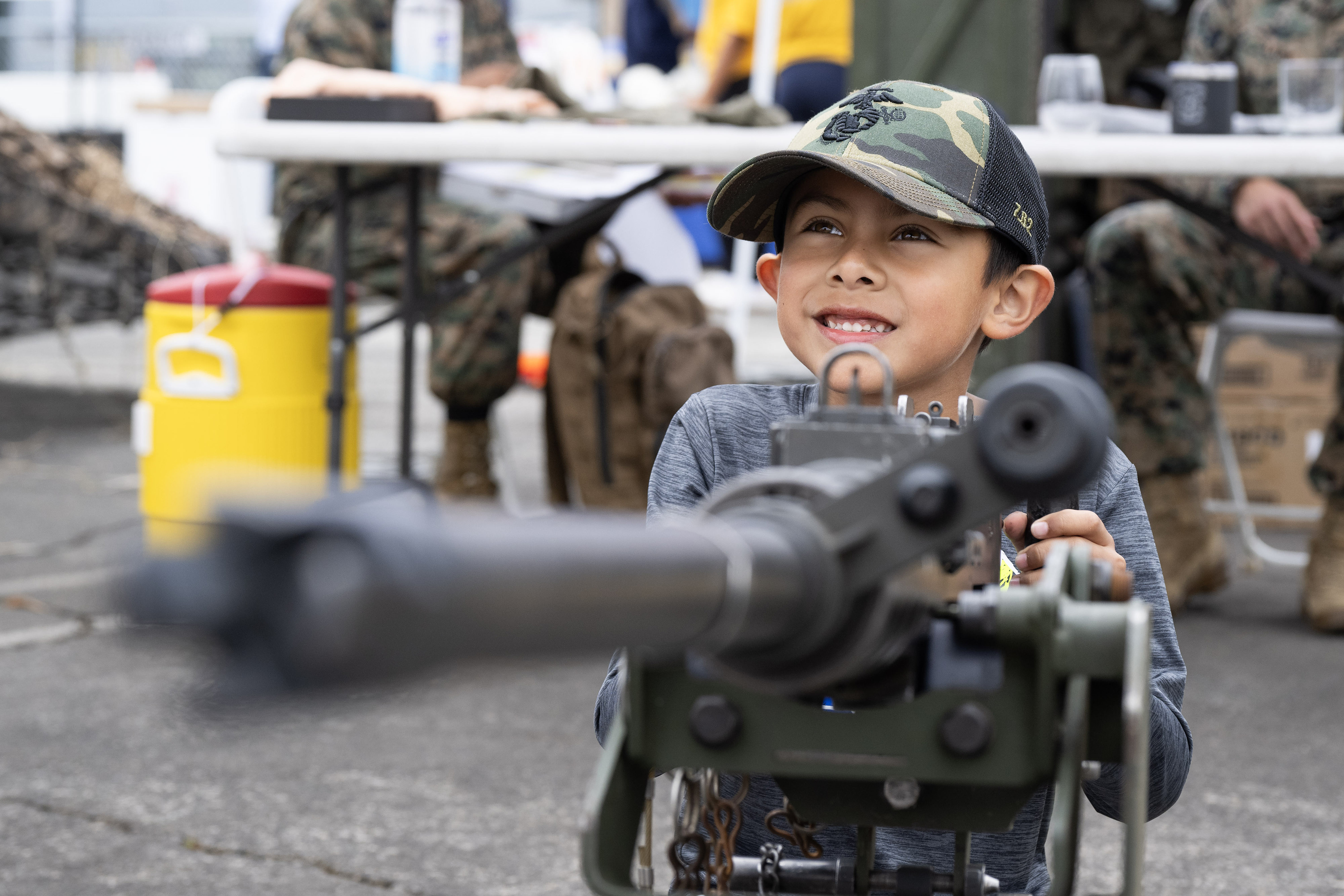 Seven-year-old Roman Ruiz poses for a photograph with an M2A1...