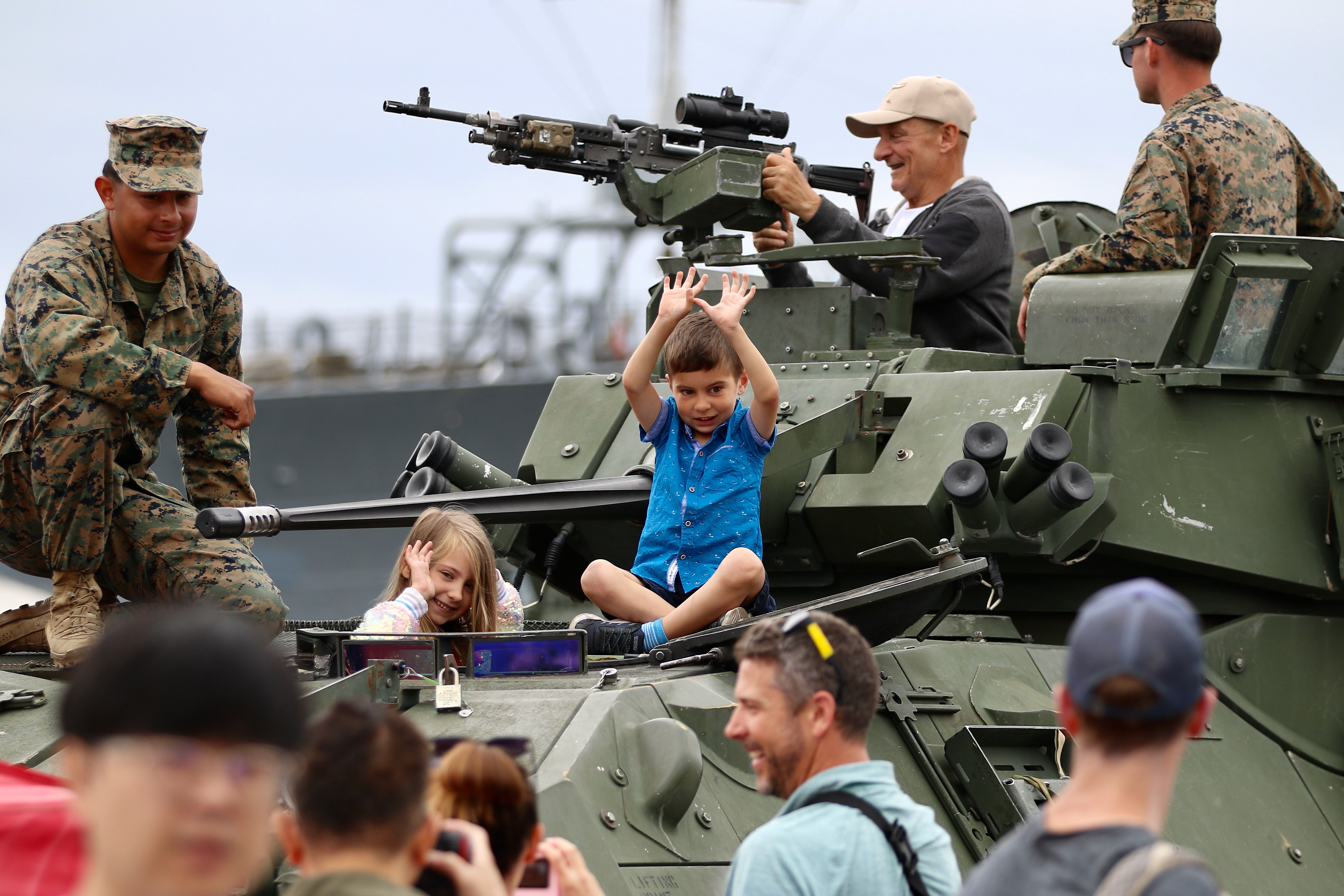 Visitors learn about equipment as they interact with military personnel...